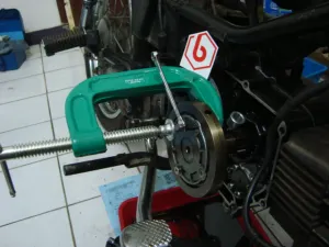 C-clamp hijau terpasang pada area penutup filter di mesin.