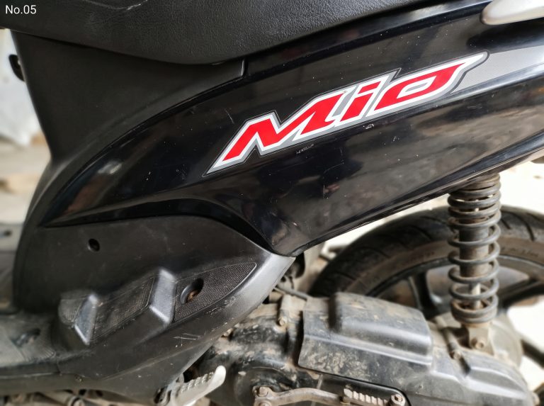 Panel bodi hitam dengan tulisan Mio, jok, dan suspensi belakang.